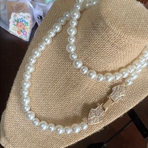 Faux pearl plunder necklace with decorative clasp.